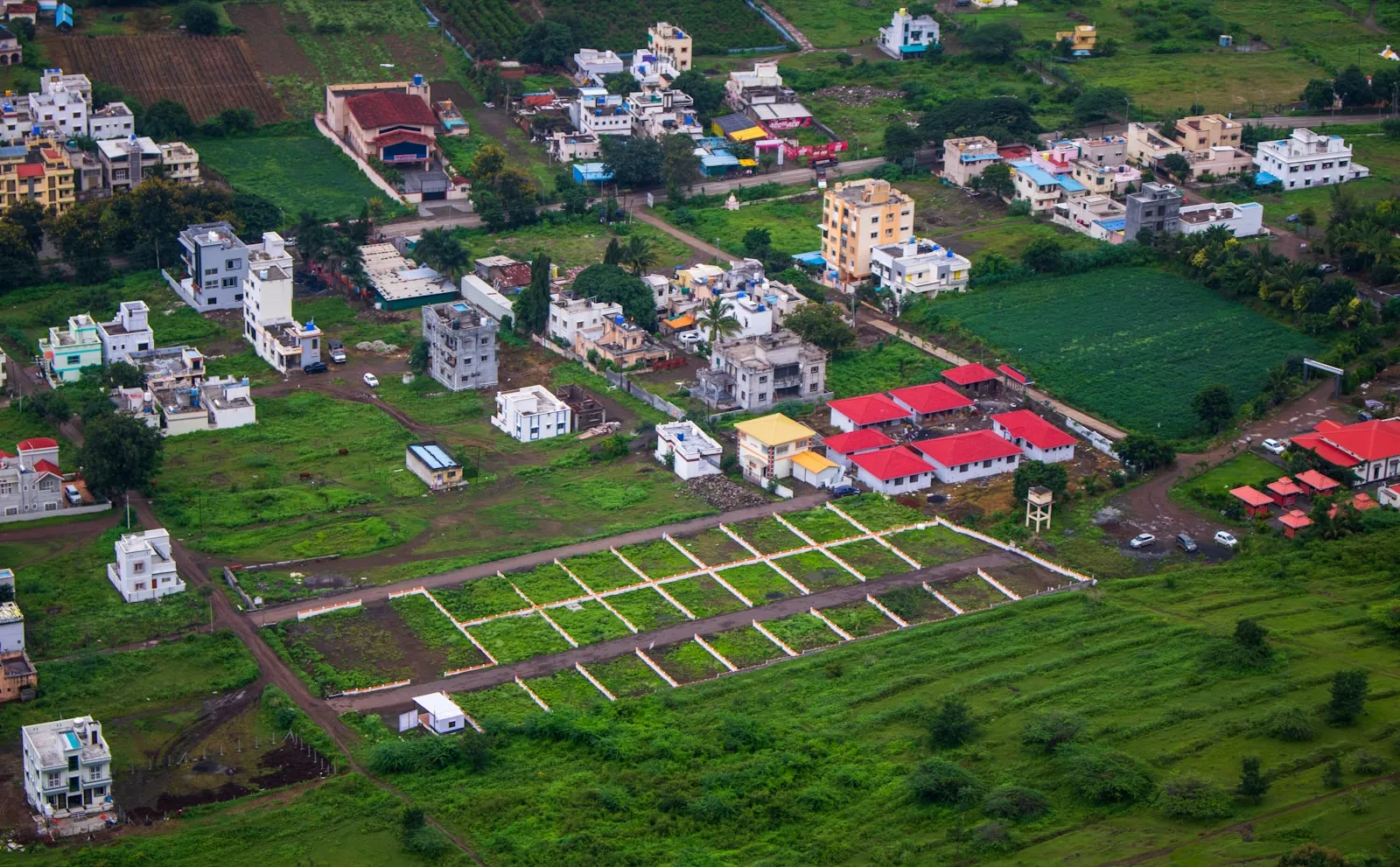Aerial view of surveyed land plots on the edge of a growing town