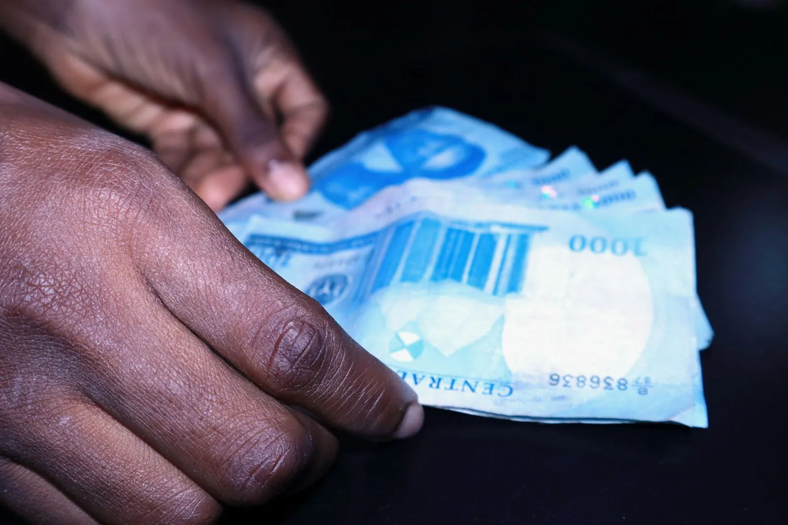 Hands counting Nigerian naira notes